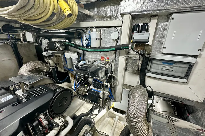 Slide: The Image of Engine room of a 2016 Absolute 72 FLY yacht with mechanical equipment and hoses. - 29