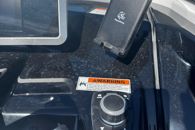 Slide: The Image of 2025 Yamaha Boats SX250 dashboard with warning label and AquaAmp device holder. - 16