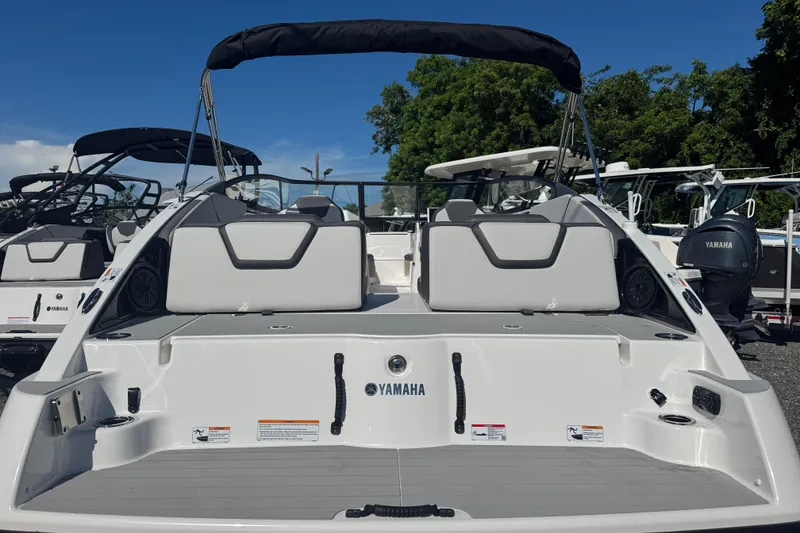 Slide: The Image of 2025 Yamaha Boats SX250, rear view, showcasing seating and deck features under clear sky. - 2