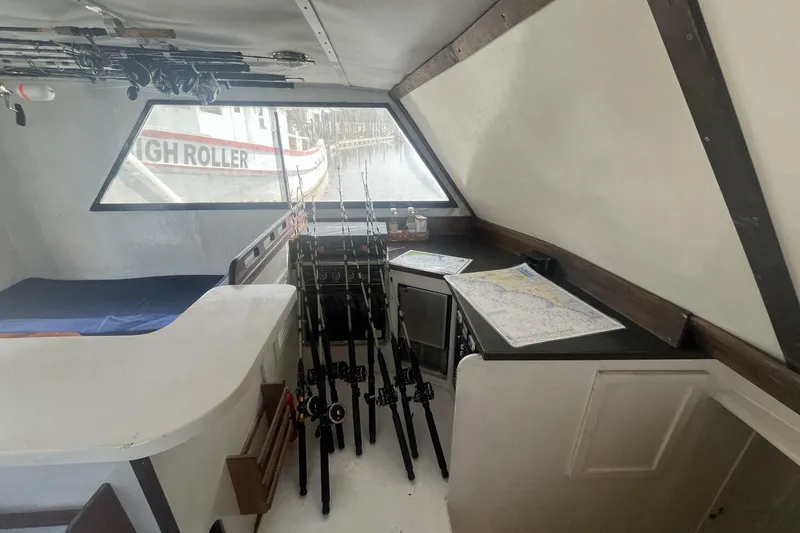 Slide: The Image of Interior of 1983 Custom Key West 39' Sportfish with fishing rods and nautical charts. - 10