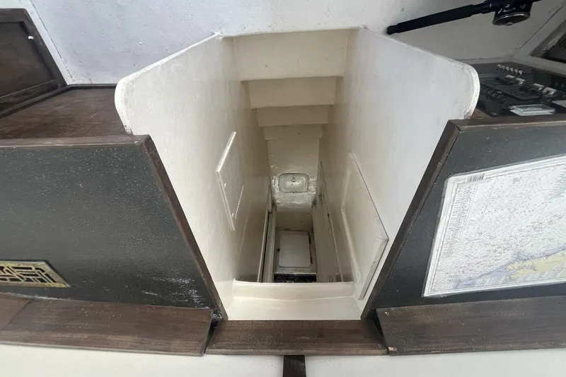 Slide: The Image of Stairway inside 1983 Custom Key West 39' Sportfish boat, featuring nautical chart. - 16