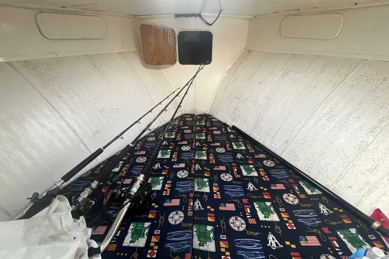 Slide: The Image of Interior of 1983 Custom Key West 39' Sportfish with fishing rods and nautical-themed bedding. - 17