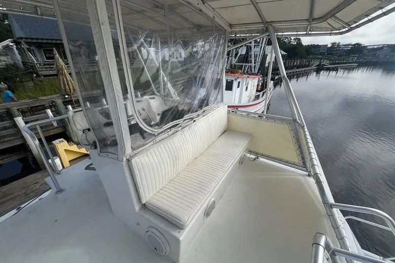 Slide: The Image of 1983 Custom Key West 39' Sportfish boat with seating area, docked by calm waters. - 25