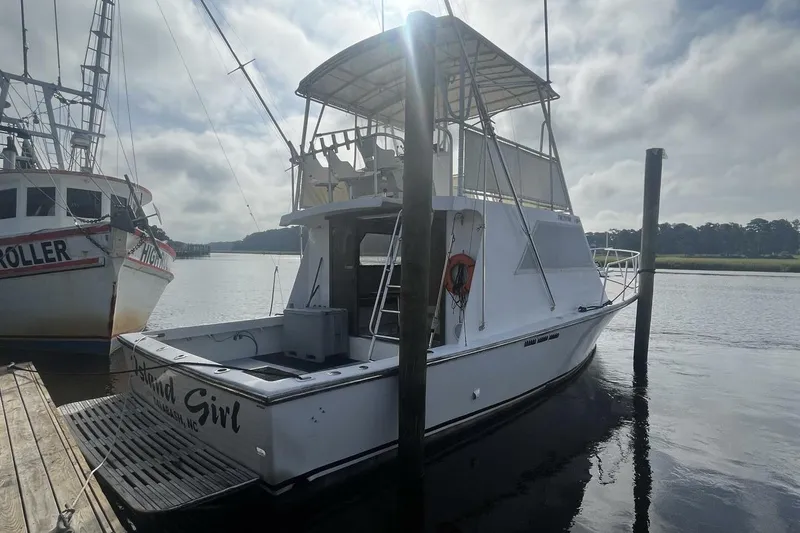 Slide: The Image of 1983 Custom Key West 39' Sportfish boat docked on a calm, cloudy day. - 3
