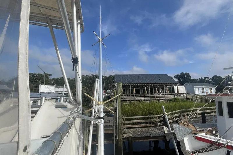 Slide: The Image of 1983 Custom Key West 39' Sportfish docked near wooden pier under blue sky. - 30