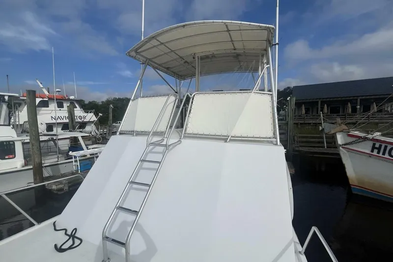 Slide: The Image of 1983 Custom Key West 39' Sportfish boat with ladder and canopy at dock. - 37
