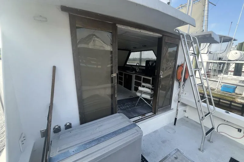 Slide: The Image of 1983 Custom Key West 39' Sportfish boat with open cabin and ladder on deck. - 6