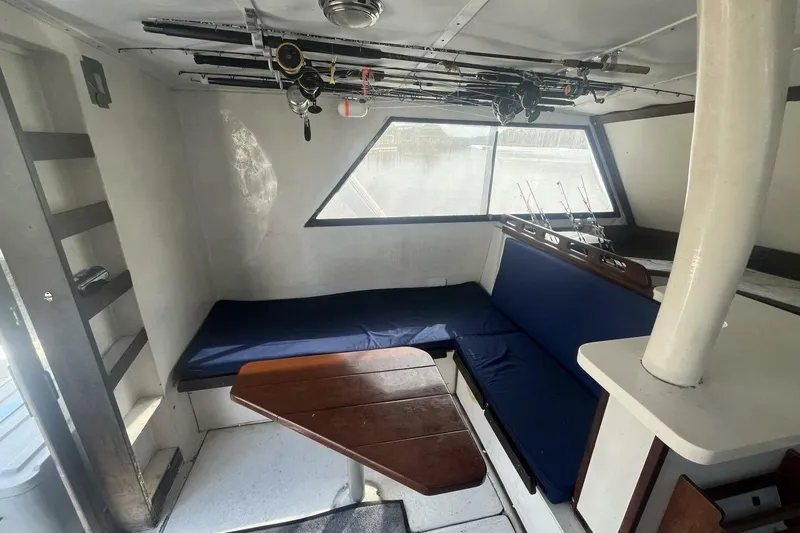 Slide: The Image of Interior of 1983 Custom Key West 39' Sportfish with fishing rods and seating area. - 8
