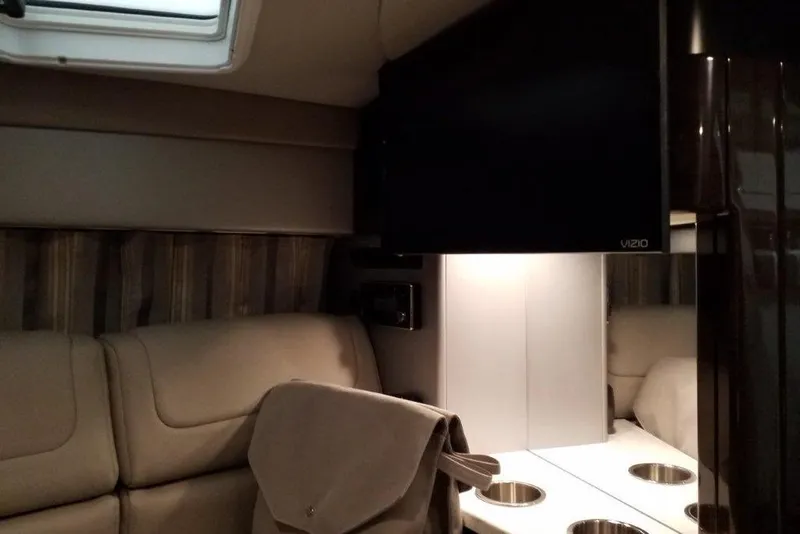 Slide: The Image of 2019 Formula 310 Sun Sport interior with beige seating and mounted TV. - 16