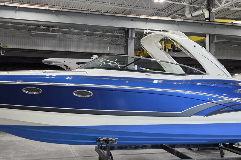 Slide: The Image of 2019 Formula 310 Sun Sport boat in a showroom, featuring a sleek blue and white design. - 3