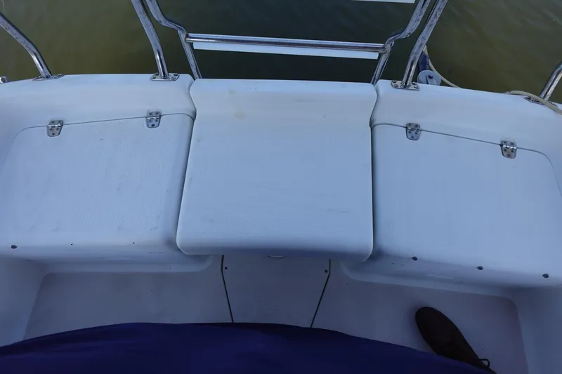 Slide: The Image of 1997 Catalina 28 boat deck with white seating and metal railings. - 16