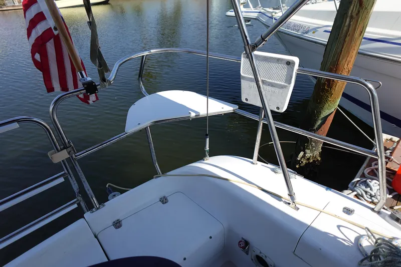 Slide: The Image of Cockpit view of a 1997 Catalina 28 sailboat docked, featuring stainless steel railings and an American flag. - 19