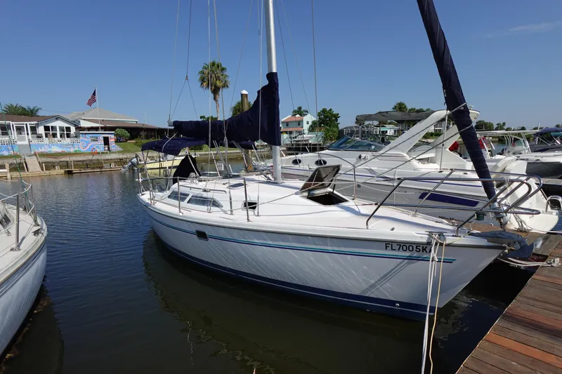 Slide: The Image of 1997 Catalina 28 sailboat docked in a marina under clear blue skies. - 2