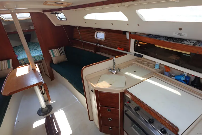 Slide: The Image of Interior of a 1997 Catalina 28 sailboat with kitchen and seating area. - 22