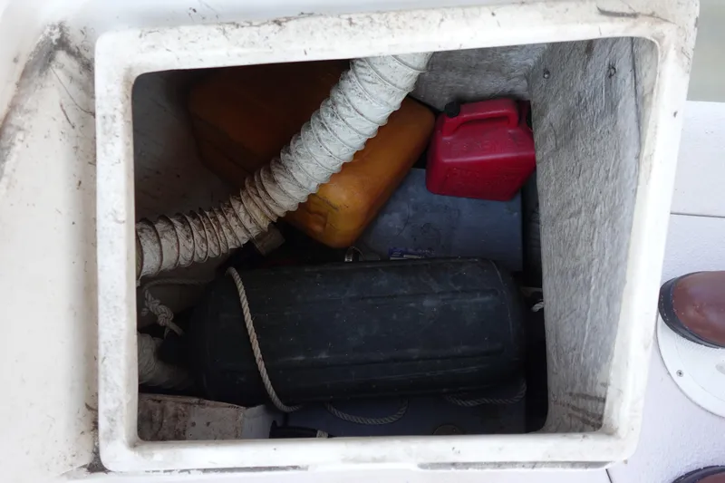 Slide: The Image of Storage compartment of a 1997 Catalina 28 sailboat with fuel containers and equipment. - 23