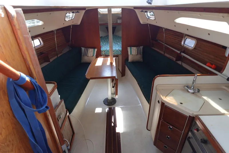 Slide: The Image of Interior of a 1997 Catalina 28 sailboat with cozy seating and compact kitchen area. - 3