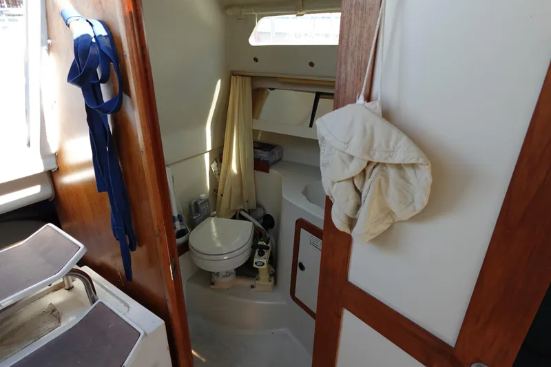 Slide: The Image of Interior of 1997 Catalina 28 sailboat bathroom with toilet and wooden accents. - 34