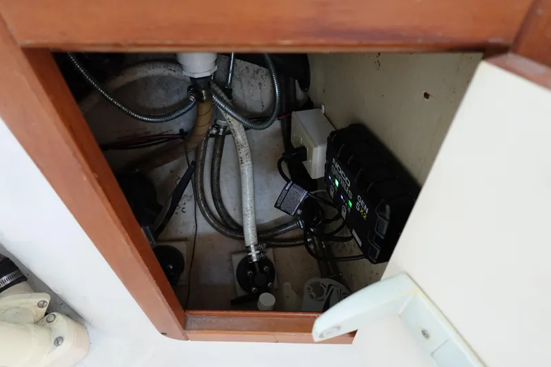 Slide: The Image of Electrical and plumbing components inside a 1997 Catalina 28 boat compartment. - 36