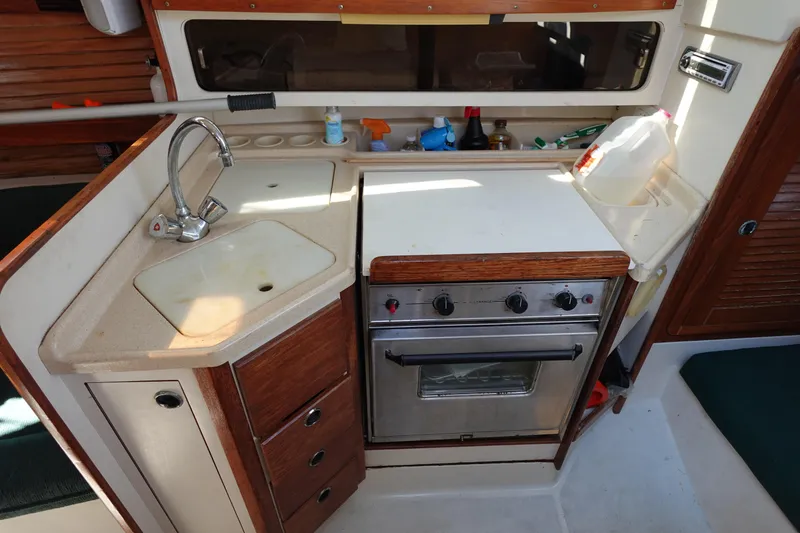 Slide: The Image of Compact kitchen in a 1997 Catalina 28 sailboat with sink and stove. - 4