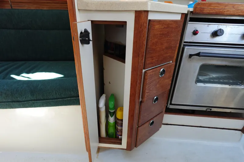 Slide: The Image of Interior of a 1997 Catalina 28 sailboat showing kitchen storage and oven. - 43