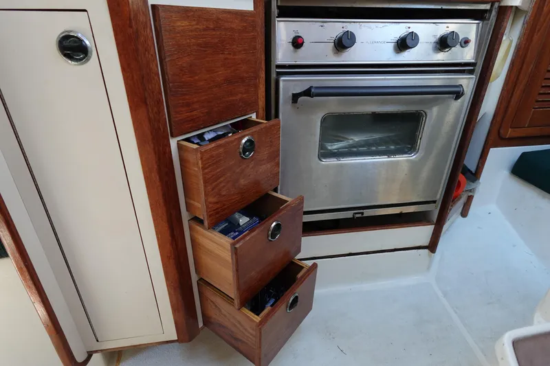 Slide: The Image of Interior of 1997 Catalina 28 sailboat with wooden drawers and stainless steel oven. - 44