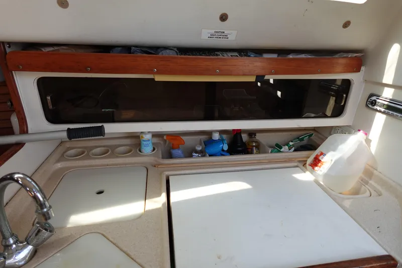 Slide: The Image of Interior of a 1997 Catalina 28 sailboat kitchen with sink and storage. - 45