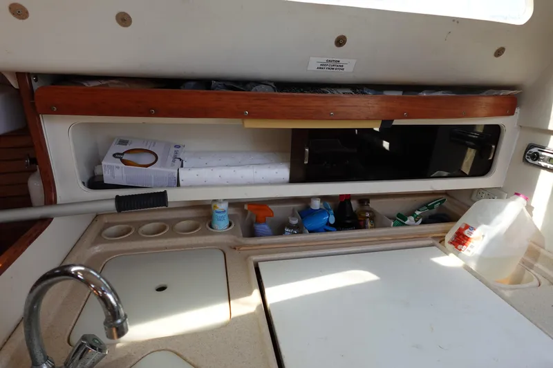 Slide: The Image of Interior of a 1997 Catalina 28 sailboat kitchen with sink and storage. - 46