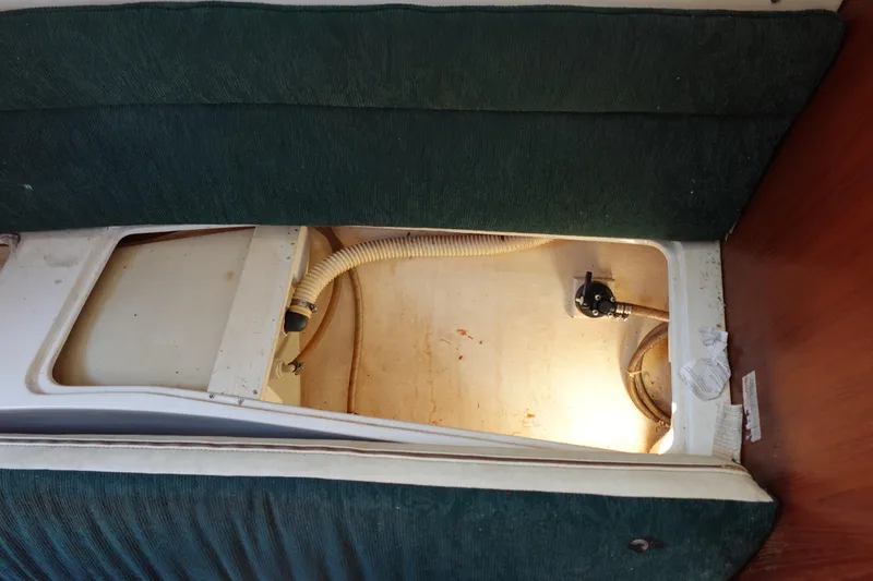 Slide: The Image of Interior view of a 1997 Catalina 28 sailboat showing storage compartment and plumbing. - 52