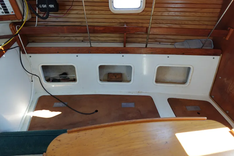 Slide: The Image of Interior of a 1997 Catalina 28 sailboat, featuring wooden accents and storage compartments. - 53