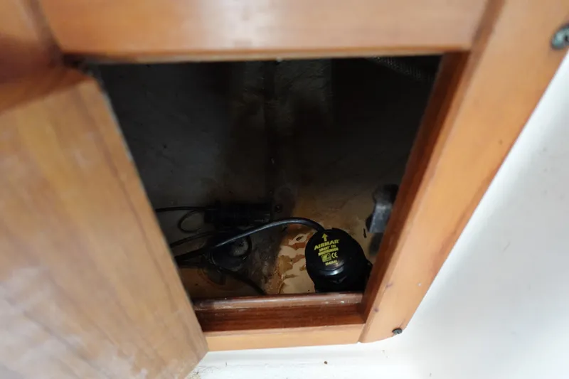 Slide: The Image of Wooden compartment in a 1997 Catalina 28 boat, showing interior wiring and components. - 60