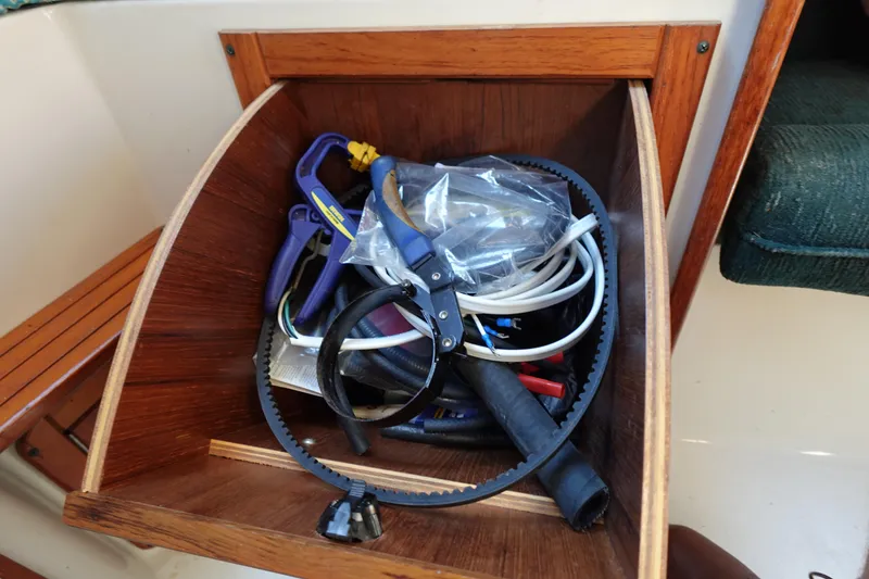 Slide: The Image of Tool storage on a 1997 Catalina 28 sailboat, featuring various maintenance items. - 62