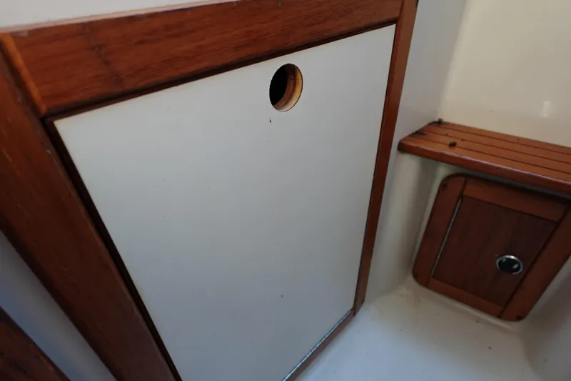 Slide: The Image of Interior of a 1997 Catalina 28 sailboat, featuring wooden cabinetry and seating. - 63