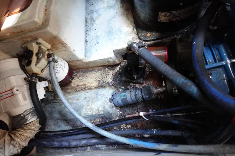 Slide: The Image of Engine compartment of a 1997 Catalina 28 sailboat, showing hoses and mechanical components. - 68