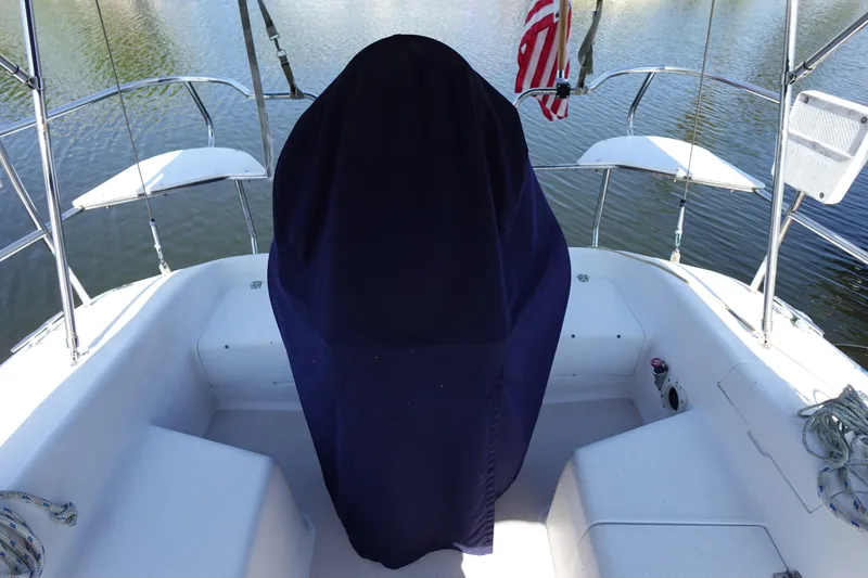 Slide: The Image of 1997 Catalina 28 sailboat cockpit with covered helm, docked on calm water. - 9