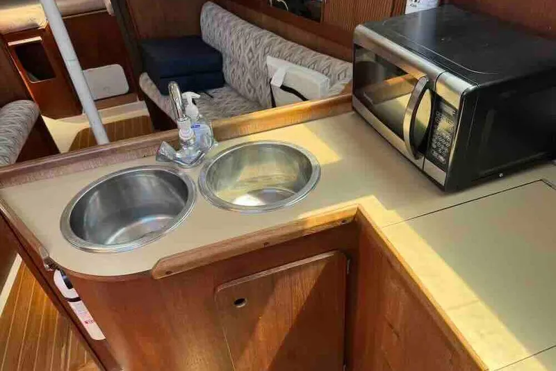 Slide: The Image of 1989 Hunter 30 yacht interior with dual sinks and microwave in the galley. - 11