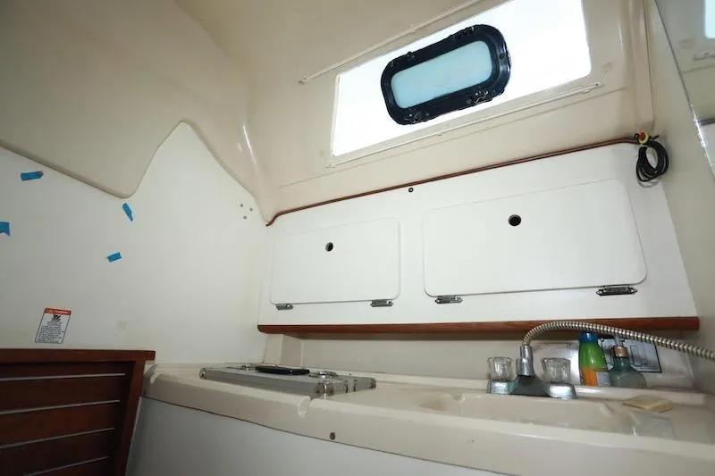 Slide: The Image of Interior of 1989 Hunter 30 sailboat galley with sink, stove, and storage cabinets. - 16