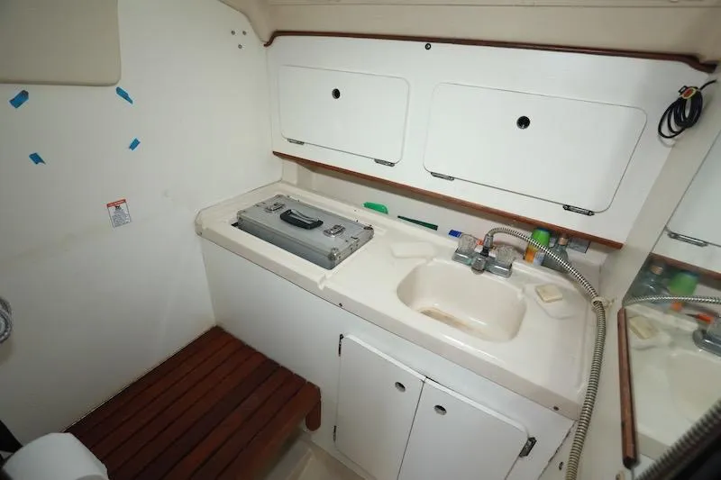 Slide: The Image of Interior of 1989 Hunter 30 sailboat bathroom with sink, storage, and wooden bench. - 17