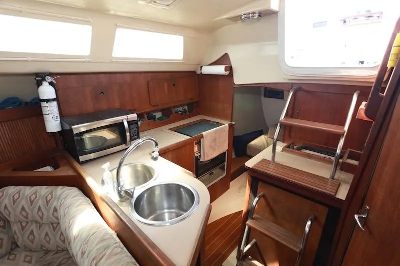 Slide: The Image of Interior of 1989 Hunter 30 sailboat with kitchen, sink, and wooden cabinetry. - 21