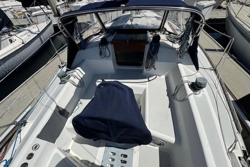 Slide: The Image of 1989 Hunter 30 sailboat cockpit with navy covers and marina background. - 22