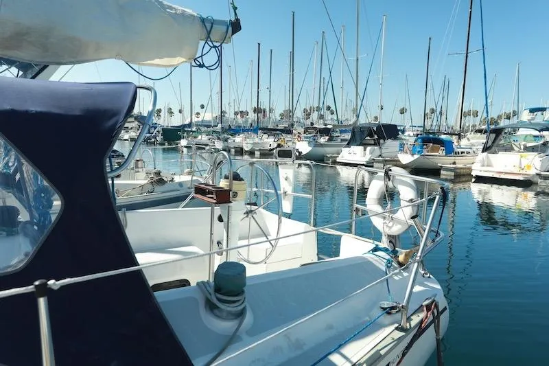 Slide: The Image of 1989 Hunter 30 sailboat docked in a marina with clear blue skies. - 3