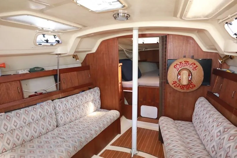 Slide: The Image of Interior of a 1989 Hunter 30 sailboat with cozy seating and wooden finishes. - 7