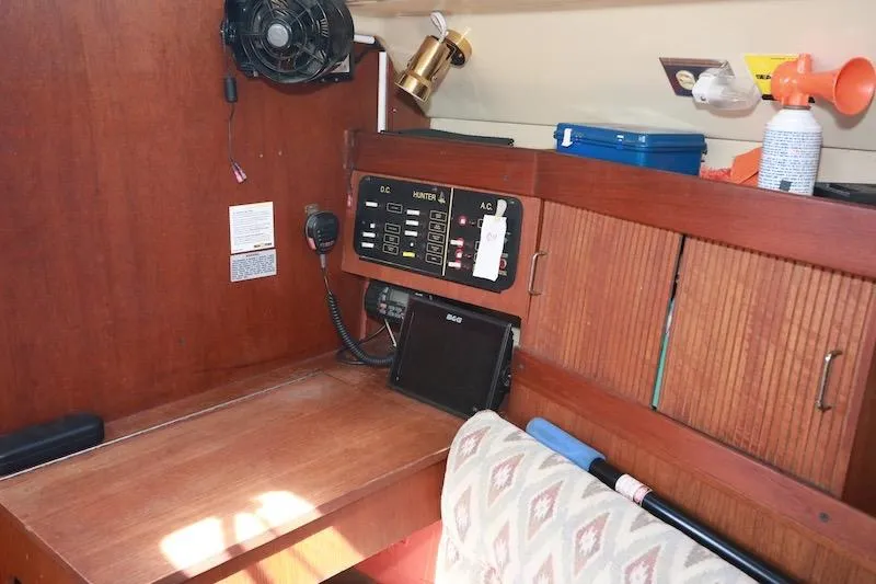 Slide: The Image of 1989 Hunter 30 sailboat interior with control panel and wooden cabinetry. - 8