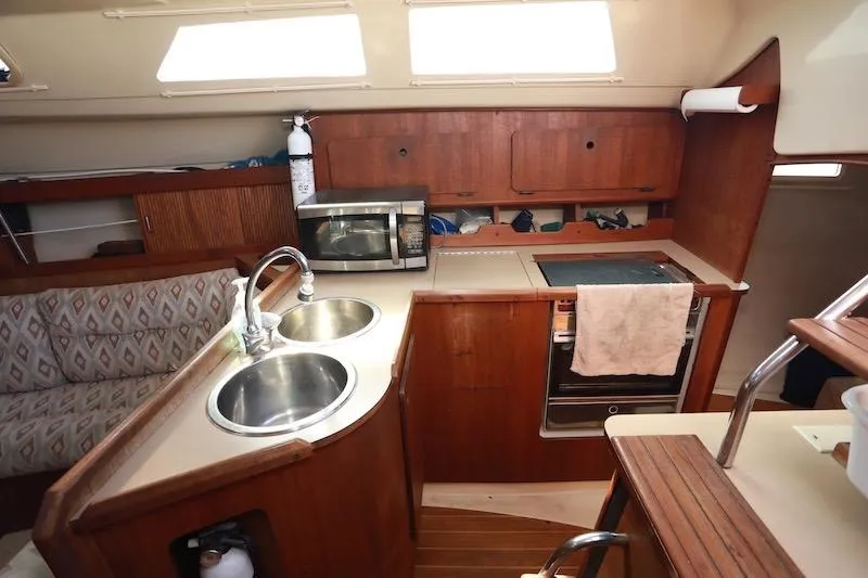 Slide: The Image of Interior of 1989 Hunter 30 sailboat kitchen with sink, stove, and microwave. - 9