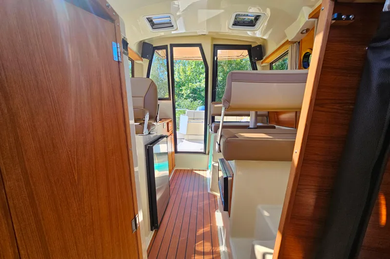 Slide: The Image of Interior of 2021 Ranger Tugs R-23 boat with wood accents and seating. - 11