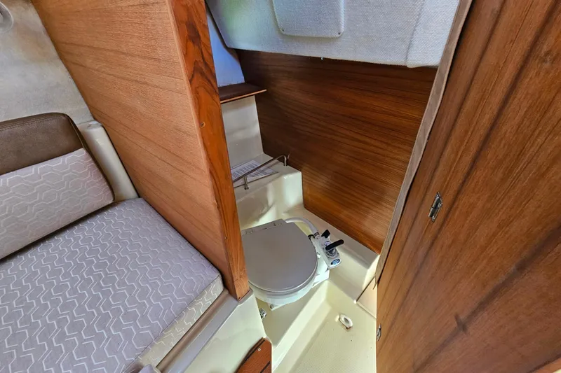 Slide: The Image of 2021 Ranger Tugs R-23 interior with compact wooden bathroom and seating area. - 12