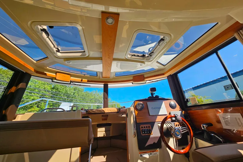 Slide: The Image of Interior view of 2021 Ranger Tugs R-23 boat with sunroof and modern dashboard. - 15
