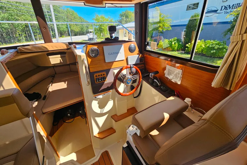 Slide: The Image of 2021 Ranger Tugs R-23 boat interior with steering wheel and navigation equipment. - 17