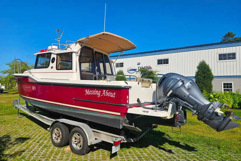 Slide: The Image of 2021 Ranger Tugs R-23 boat on trailer, red and white, with outboard motor. - 4