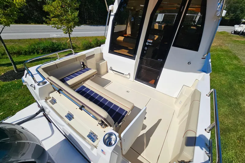 Slide: The Image of 2021 Ranger Tugs R-23 boat with spacious deck and seating area, parked outdoors. - 7