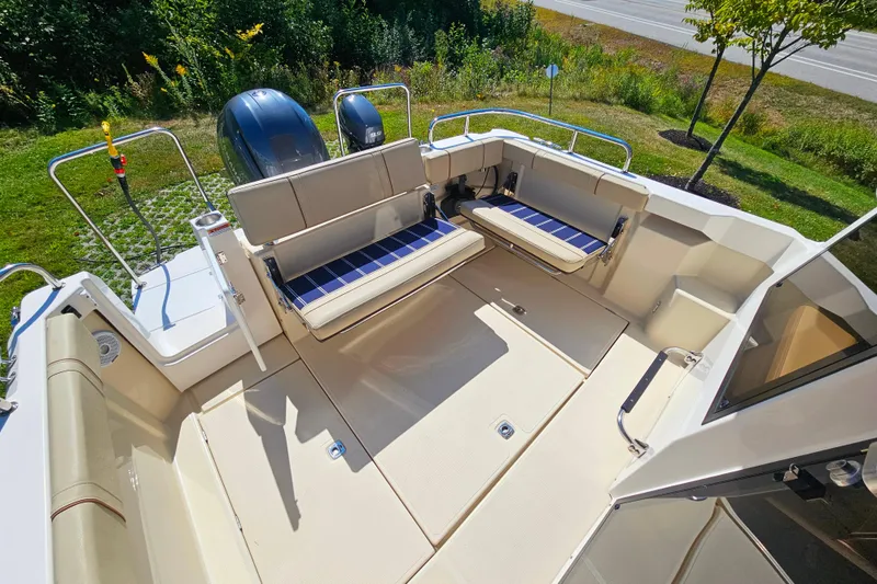 Slide: The Image of 2021 Ranger Tugs R-23 boat deck with seating, outdoor view, and twin engines. - 9